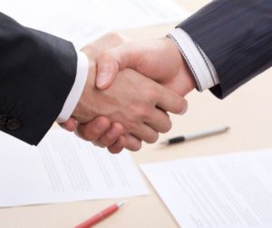 Two men shaking hands after a business transition with Private Equity