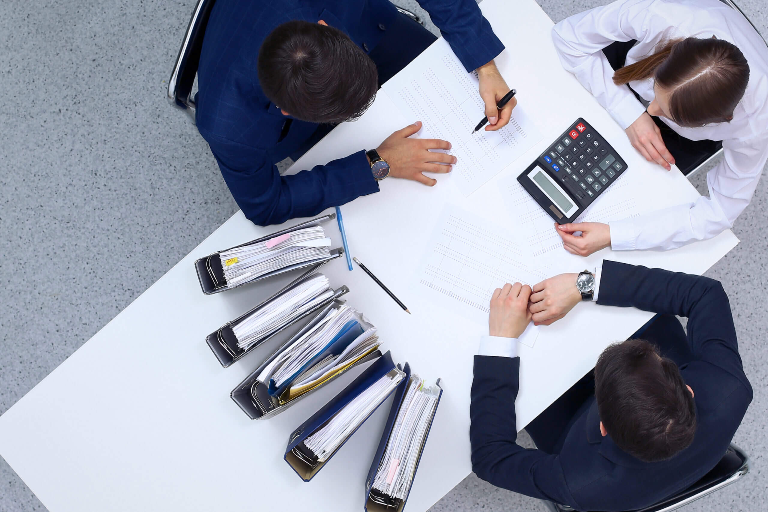 Business people at meeting, view from above. Bookkeeper or financial inspector making report, calculating or checking balance. Internal Revenue Service checking financial document. Audit and tax concept.